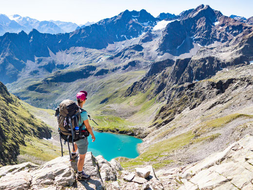 Wandern im Pitztal: Wanderin blickt auf türkisfarbenen Bergsee in hochalpiner Umgebung