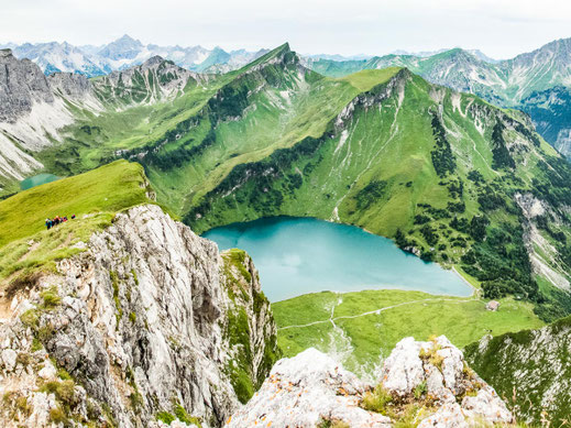 Vilsalpsee im Allgäu: Blick über den Bergsee auf die umliegenden Grasberge und alpine Landschaft