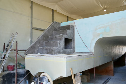 Die laminierte Treppe mit Öffnung für grosse Fender ist platziert und wird per Laminat mit dem Rumpf verbunden.