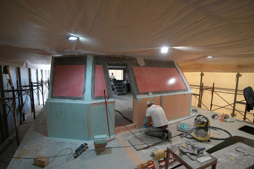 Vom Bug her gesehen; ein Mitarbeiter von Marservis kittet und schleift Unebenheiten an der Frontwand.