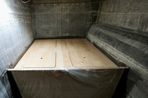 Blick im Steuerbordrumpf zum Doppelbett mit vier Öffnungen zum Stauraum.