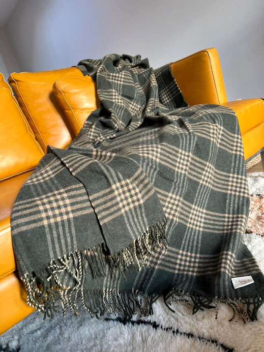 Natural wool blanket on sofa, perfect for living room or bedroom decor..