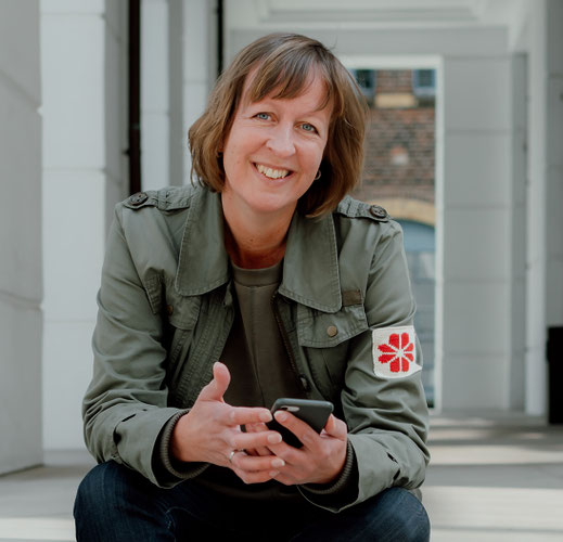 Porträtfoto von Alex Drews. Alex sitzt und blickt in die Kamera.