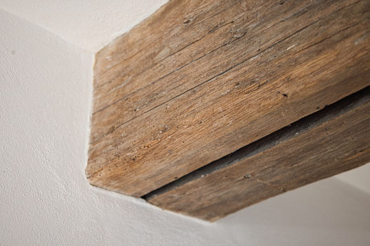 weißer Lehmputz an nicht geölten Holzbalken