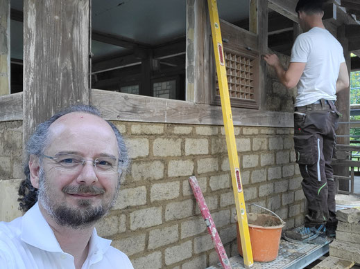 Bei der Arbeit, die Gefache werden mit Lehmsteinen ausgemauert