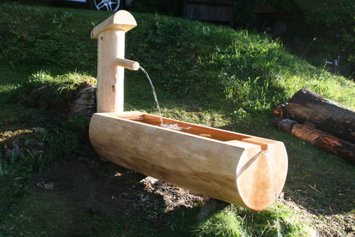 Holzbrunnen aus Lärche Rundholz Gartenbrunnen mit Wasser Schweiz handgefertigt.