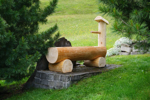 Holzbrunnen aus Lärche im Garten auf Naturstein montiert handgefertigt Schweiz.