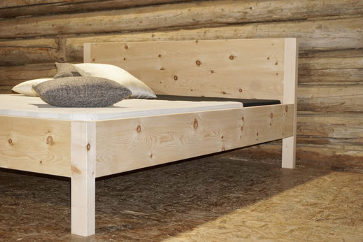 Handgefertigtes Arvenbett aus Massivholz mit natürlicher Holzmaserung.