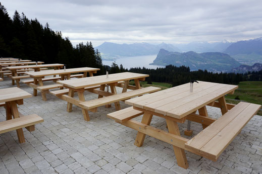 Tischgarnitur Dartet aus Lärche auf einer Terrasse mit Berg- und Seesicht.