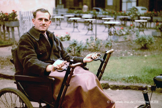 Fotograf Karl Heinz Mai, Deutschland, im Rollstuhl um 1953 in Leipzig. Farbfoto.