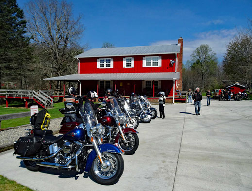 Motoglobe_Motorradreisen. Die Harley Davidson Motorräder stehen auf dem grossen Parkplatz vor dem Gebäude der Unterkunft Two Wheels of Suches.