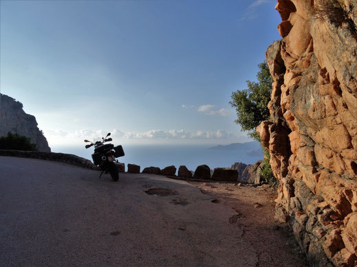 Motorradreisen Bild mit Strasse, Motorrad, Felsen und Blick aufs Meer
