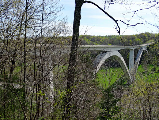 Motoglobe_Motorradreisen. Eine grosse weisse Brücke mit zwei Bögen führt über ein grünes Tal auf dem Natchez Trace Parkway Richtung Nashville.