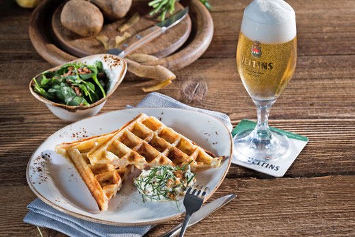 Bei Speckwaffeln mit Petersilien-Nuss-Creme handelt es sich um eine genussvolle, herzhafte Vorspeise. Ein erfrischendes Pils ist dazu die richtige Kombination. Foto: djd/Brauerei C. & A. Veltins