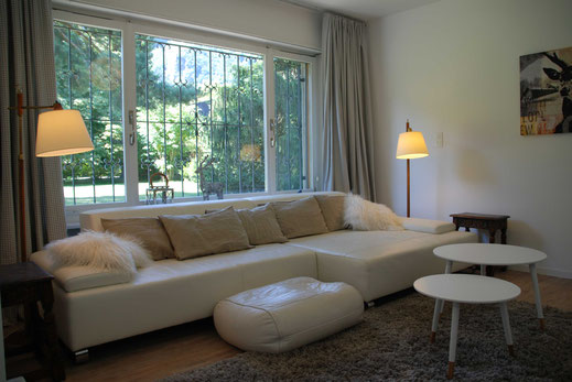 Lounge mit weißer Couch in der Mastersuite und Blick nach draußen - Chalet Bad Ragaz Ferienhaus Schweiz