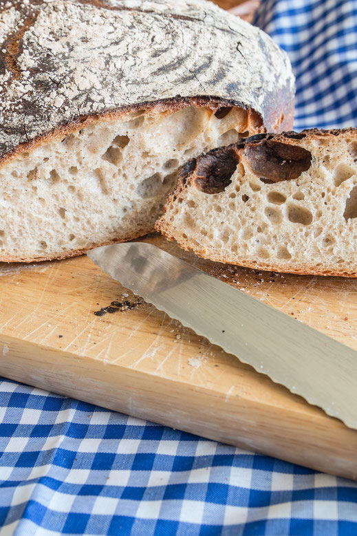 Weizen-Sauerteigbrot angeschnitten auf Holzbrett