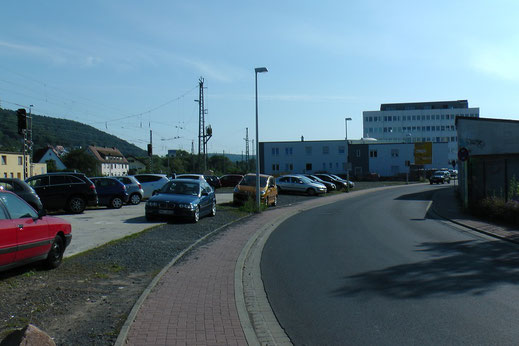 Dort wo heute die Zufahrtsstraße verläuft, war das Ausfahrtsgleis der Spessartbahn. Auf dem Parkplatz links stand das Bahnhofsgebäude (auf der Karte oben in blau). Bis zur Errichtung des gemeinsamen Bahnsteiges, endeten die Personenzüge hier.