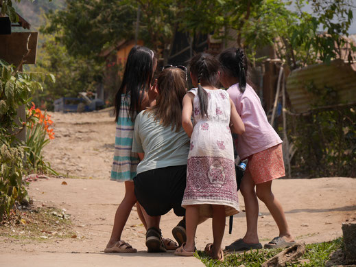 Andere Touristen zeigen den Mädchen des Dorfes die gerade von ihnen geschossenen Fotos... Muang Ngoy, Laos (Foto Jörg Schwarz)