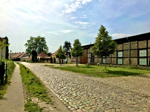 Dorfstraße in Paretz: Die historisch gepflasterte Werderdammstraße mit der "Paretzer Scheune", Mehlwaage, Leiterschauer & Spritzenhaus.