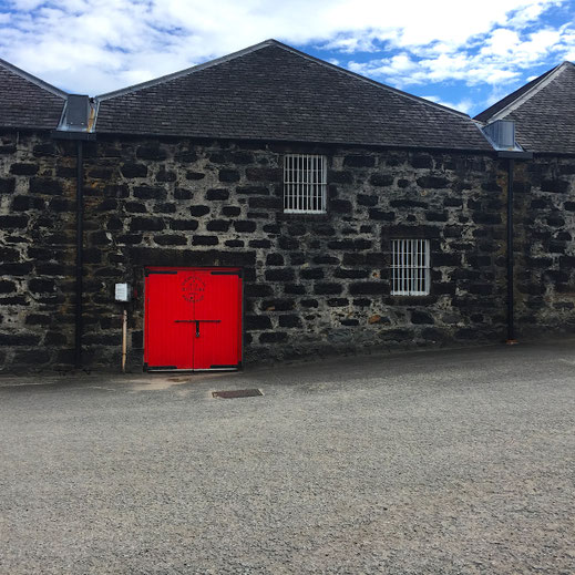 Whisky-Destillerie in Schottland mit rotem Tor