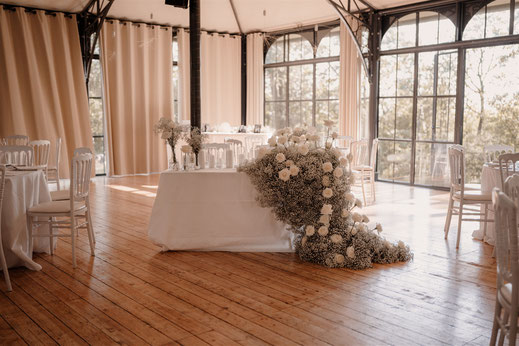 Table d’honneur décorée pour un mariage à Paris (Ile-de-France) avec cascade de fleurs blanches et gypsophile