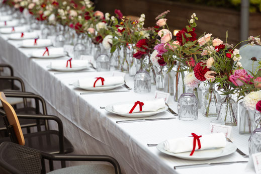Décoration de mariage à Paris avec table élégante, fleurs colorées et rubans rouges