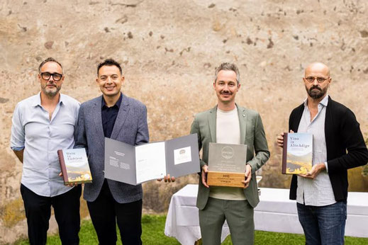 Premiazione della Cultura Vitivinicola Alto Adige: Andreas Kofler, Junior Nunes, Michael Meister (Ristorante Löwengrube) ed Eduard Bernhart con il premio e i libri.