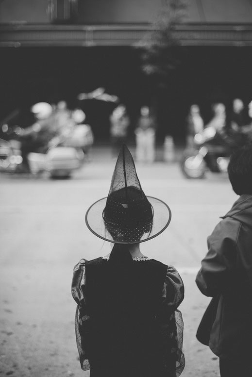 a girl in a wizard costume watching a Halloween parade