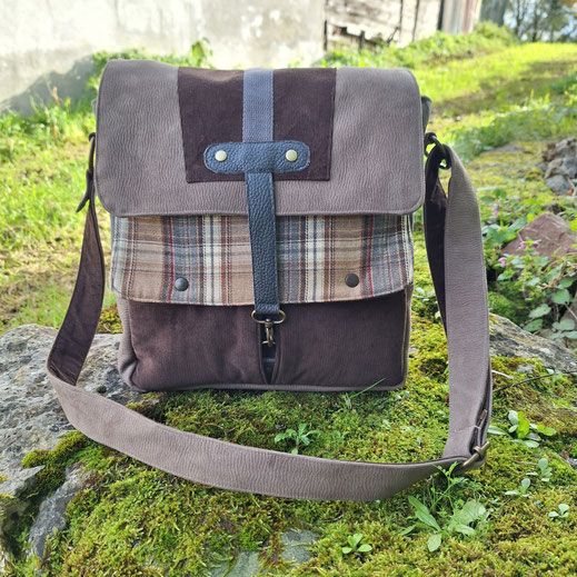 sac à bandoulière homme multi matières, besace artisanale en simili cuir et tissu tartan à carreaux beige, couleurs naturelles, thème nature forêt et montagnes, artisanat français, nombreuses poches et compartiments
