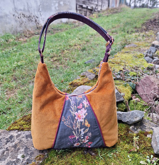 sac hobo femme en velours côtele caramel  / jaune et aubergine, tissu gris foncé avec des fleurs sauvages.