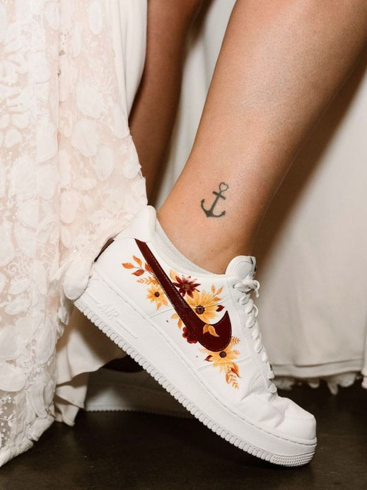 Bruid draagt beschilderde sneakers met bloemen en trouwdatum tijdens trouwdag