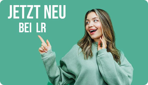 Junge Frau zeigt voller Freude auf die LR Produktneuheiten - Jetzt alle LR Produktneuheiten ansehen