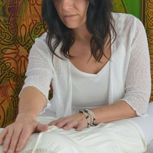 Bianka Geier berührt achtsam die Hände einer liegenden Frau