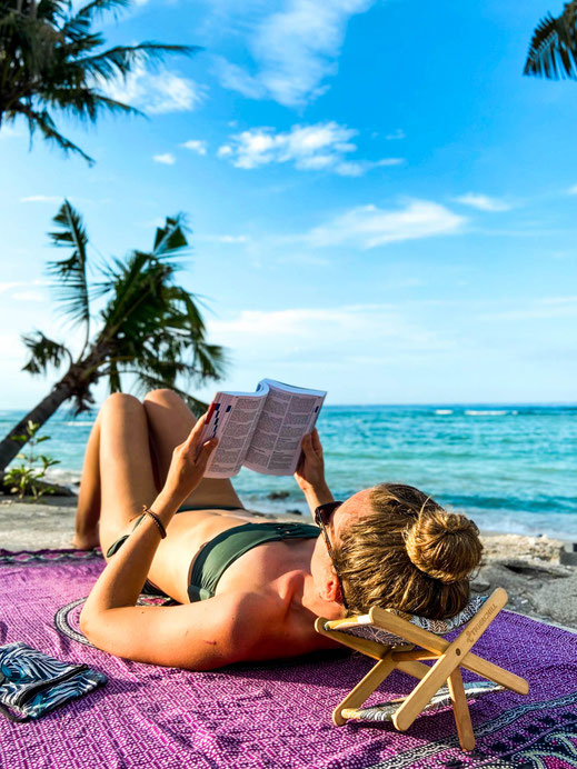 Frau entspannt am Strand von Sansibar mit einer Headbank (Kopfstütze) von Tigerchill.