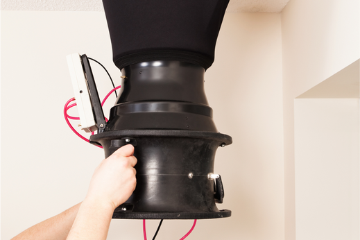 Prise de mesure avec un anémomètre sur une grille de ventilation.