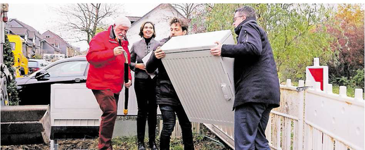 Tim Grüttemeier und Patrick Haas schleppen den Verteilerkasten herbei, während sich Anja Wilhelm und Paul Kirch schon einmal mit dem Glasfaserkabel befassen, das schnelles Internet in bislang unterversorgte Gebiete bringen soll.. Foto: J. Lange