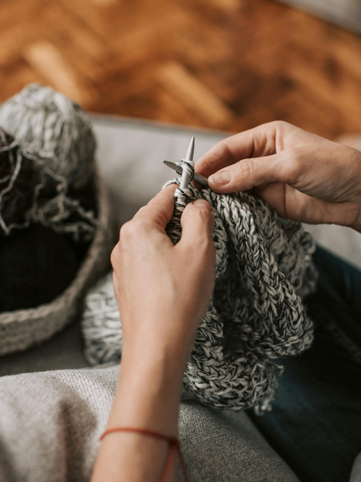 Hands holding a knitted piece, soft light and natural texture