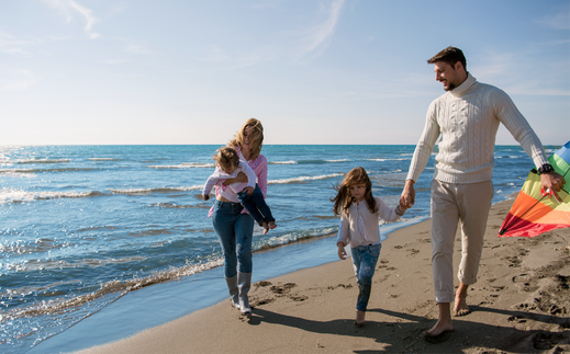 Das Bild eine Familie, die am Strand Spaß hat.