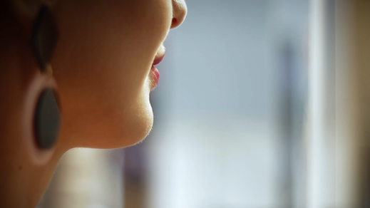 Gros plan de trois-quarts dos sur le visage d’une femme lors du tournage d’une vidéo promotionnelle
