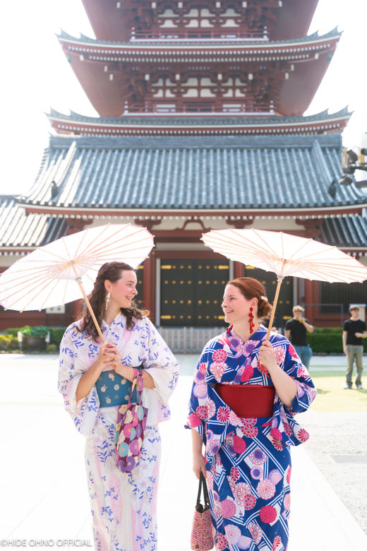 Two women in colorful kimonos holding traditional umbrellas and smiling together at Senso-ji Temple in Asakusa — perfect for friends enjoying a Tokyo kimono photoshoot.