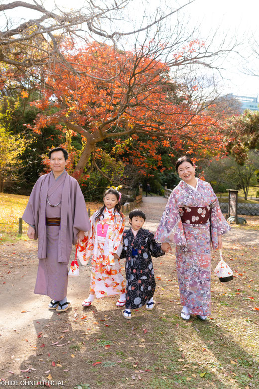 Family in kimono walking together under autumn foliage in Asakusa — candid photoshoot capturing warm Japan memories.