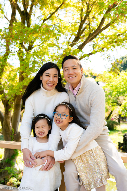 Family smiling together under the trees in Shinjuku Gyoen, capturing relaxed and natural moments in Tokyo.