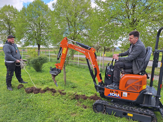 Minibagger mit zwei Bauarbeitern bei der Arbeit