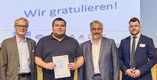 Absolvent mit Urkunde neben den Gratulanten