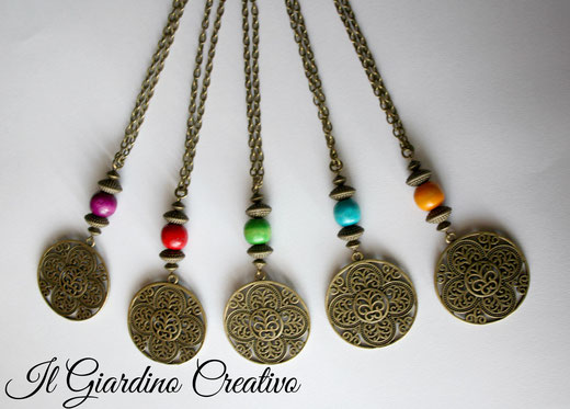 Collane "Maishi " Realizzate con minuteria, pendente traforato e perle in metallo color bronzo. Decorate con perle in legno in vari colori.