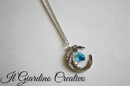 Collana "Luna" Realizzata con dettagli e ciondolo a forma di luna color argento. Decorata con goccia in cristallo azzurro.