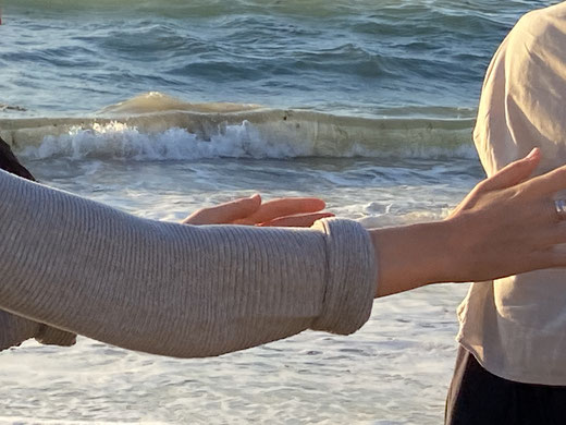 Junge Frau macht die Taichi-Langform am Strand, Detail ihrer Hände