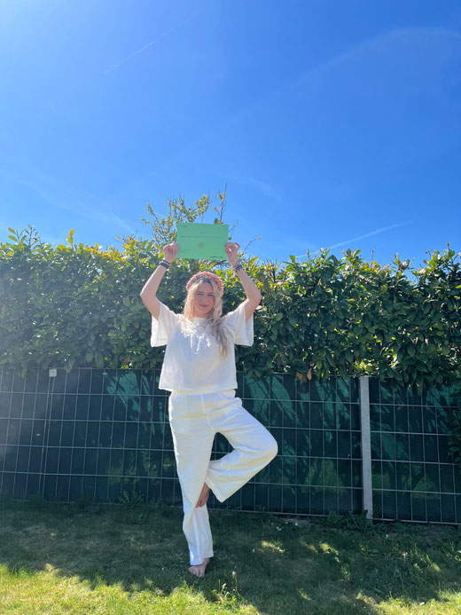 Anna in Baumpose mit ihrem 200h Teacher Training Zertifikat