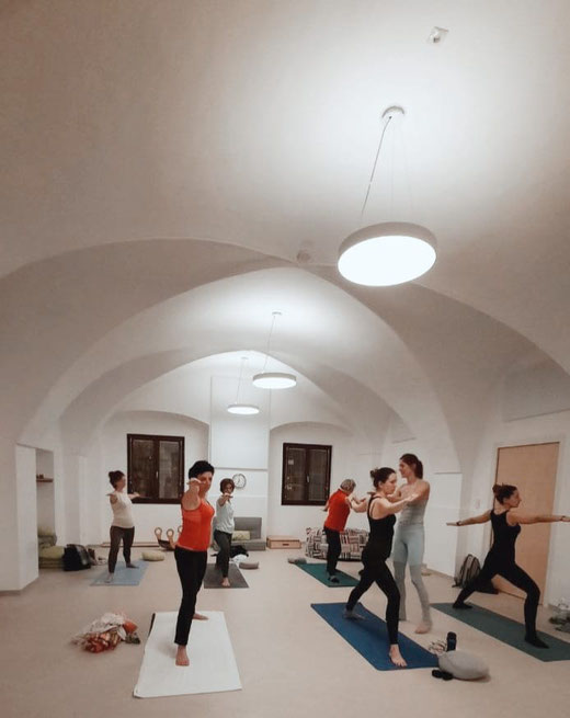 Krieger 2 Position ausgeführt von Yogaschülerinnen auf ihren Yogamatten