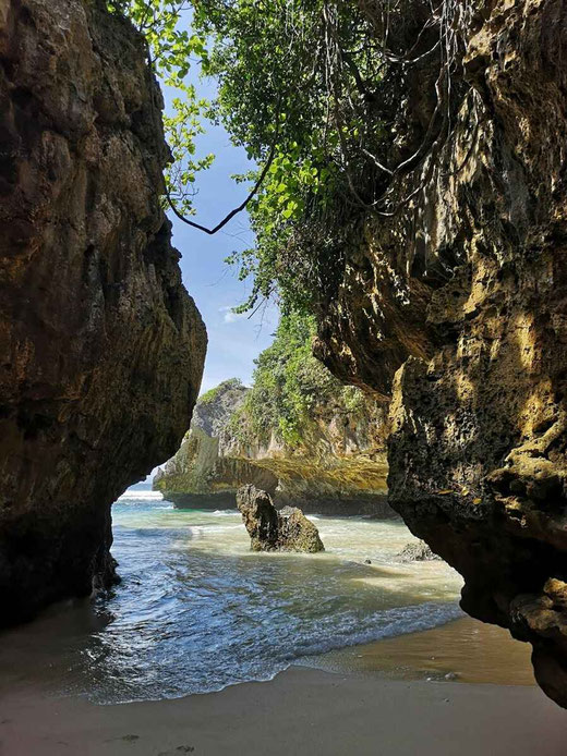 Vista oculta del mar turquesa enmarcado por rocas en la playa de Suluban.